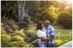 This lovely photo of Nikki and Leon beautifully captures a romantic summer moment at Chateau Ste. Michelle. Bathed in golden-hour light, the couple shares a tender kiss surrounded by lush gardens, blooming flowers, and towering trees—a perfect blend of elegance and nature. Their coordinated casual-chic outfits add a relaxed charm to the setting, making this an ideal highlight for a couples session
