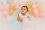 Avya’s 1st birthday family photos in a downtown Everett studio with colorful balloons, capturing joyful family smiles and a baby celebrating her first birthday.