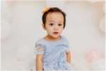 Two young sisters celebrating their 1st and 3rd birthdays in a downtown Everett photography studio wearing elegant dresses during a birthday portrait session.