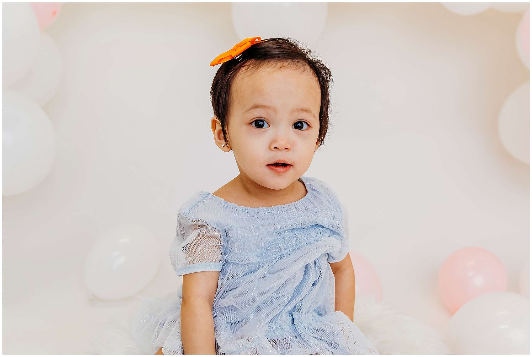 Two young sisters celebrating their 1st and 3rd birthdays in a downtown Everett photography studio wearing elegant dresses during a birthday portrait session.