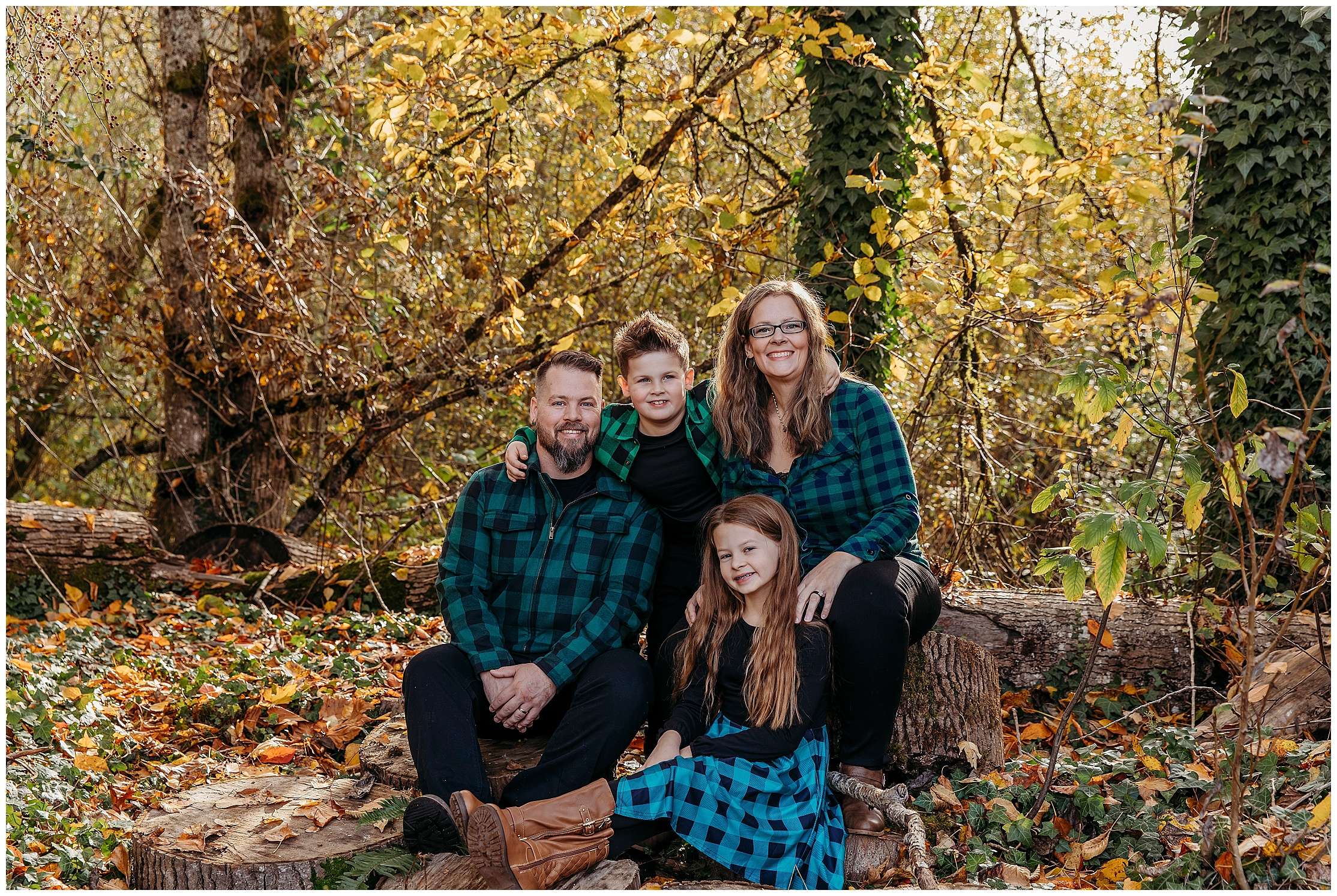 Family of four walking hand in hand on a wooden bridge at Bothell Landing in Bothell, Washington, during a November fall mini session surrounded by golden autumn leaves.