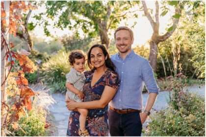 Family of three with a five-year-old child walking together through Bellevue Botanical Garden in late summer surrounded by lush greenery